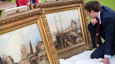 Art expert Lawrence Hendra examining pictures