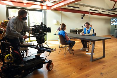 Megan Roberts (AIMEE-FFION EDWARDS), Danny Howells (CRAIG PARKINSON) Behind the scenes. (L-R) on Life and Death in the Warehouse (Image Credit: BBC/Simon Ridgway)