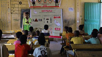 A member of Community Focal Points (CFPs) team speaking in a school