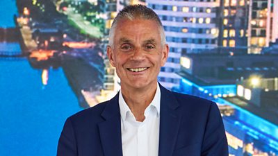Photo of BBC Director-General Tim Davie smiling to the camera.