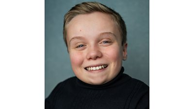 Lenny Rush smiles to camera in a headshot